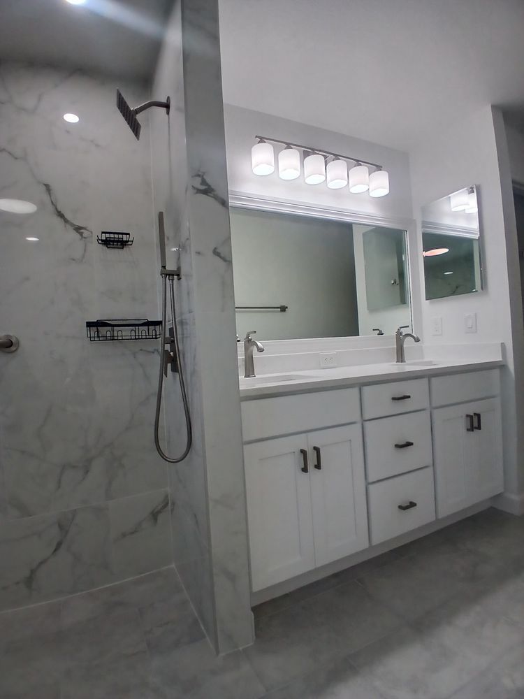 A bathroom with two sinks and a walk in shower