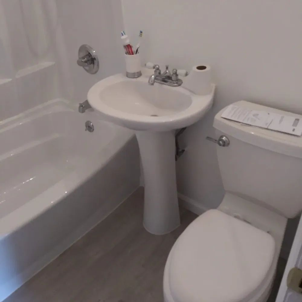 A bathroom with a toilet a sink and a bathtub