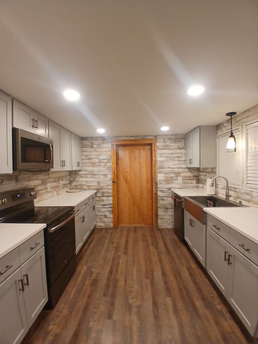 A kitchen with wooden floors and white cabinets