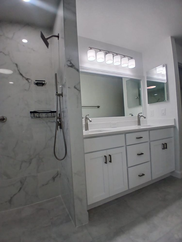 A bathroom with two sinks and a walk in shower