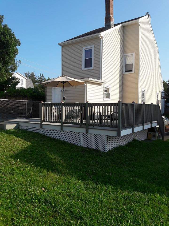 A house with a deck and umbrella in front of it