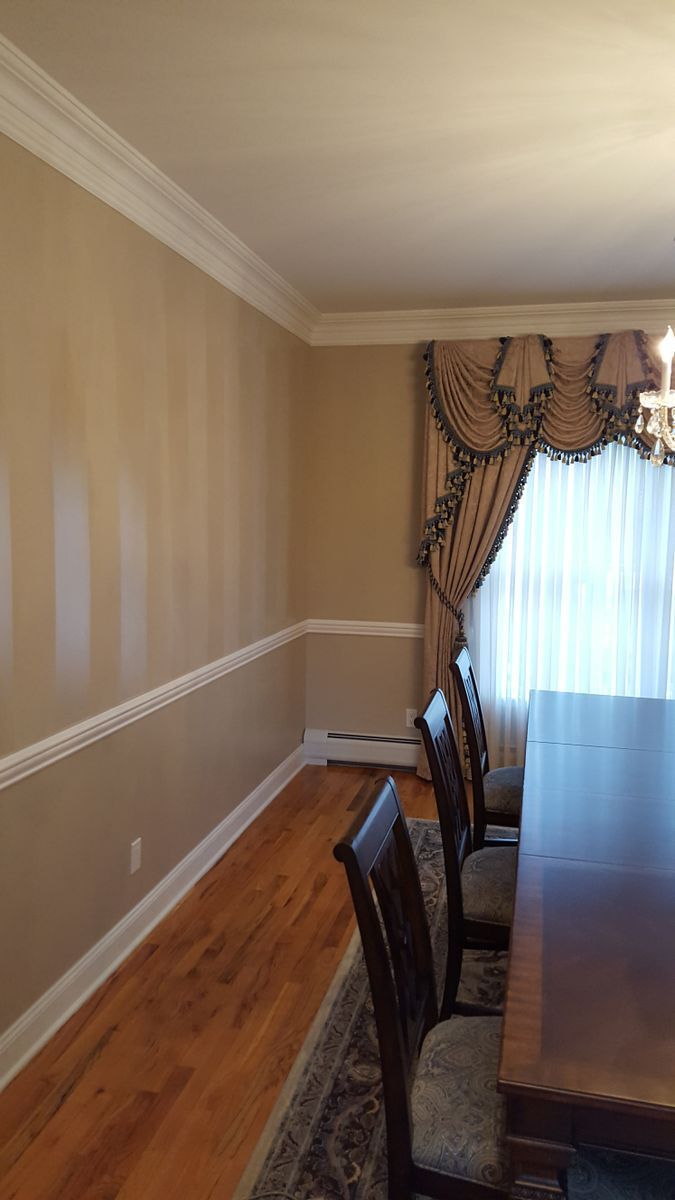 A dining room with a table and chairs and a window