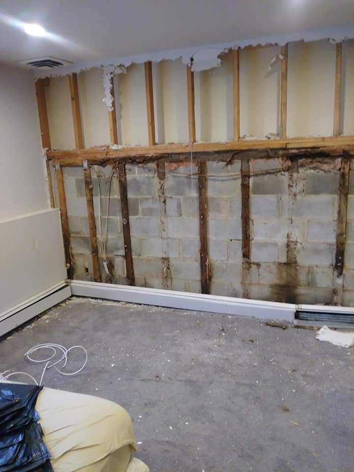 A living room with a couch and a brick wall.