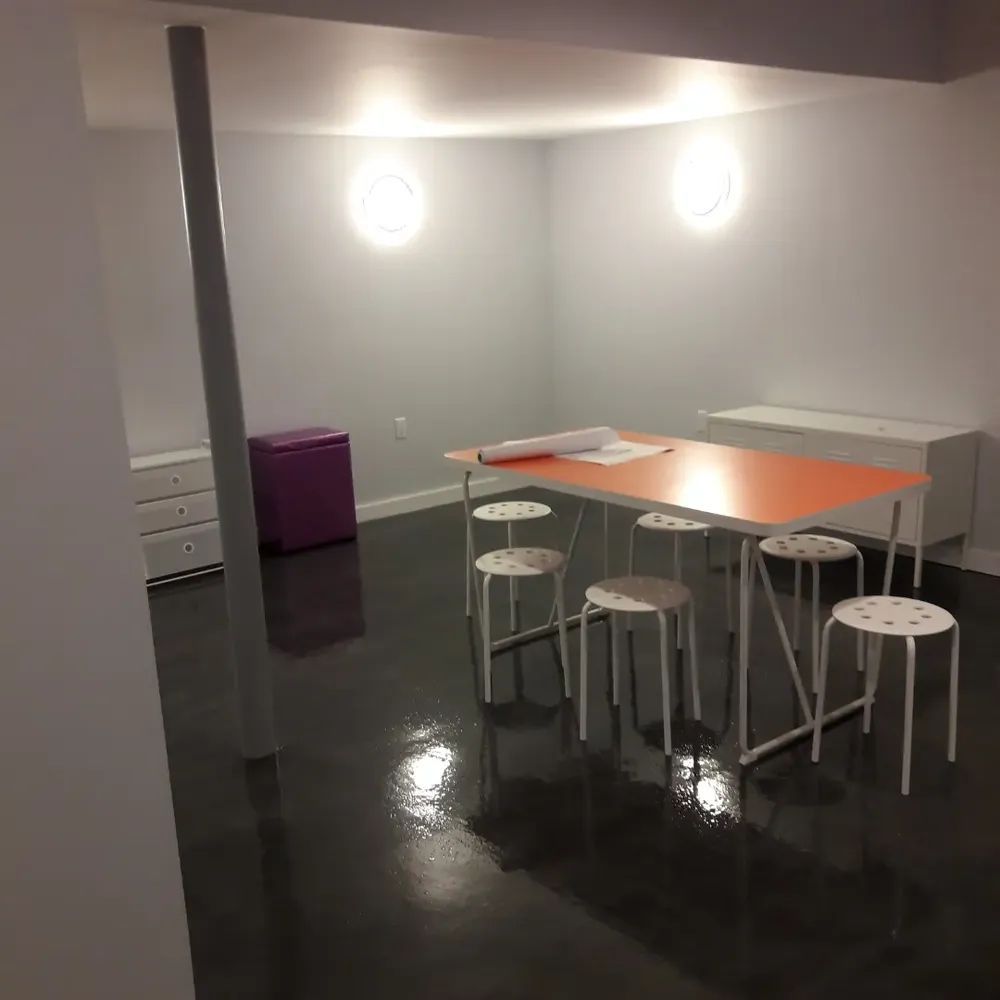 A room with a table and stools in it