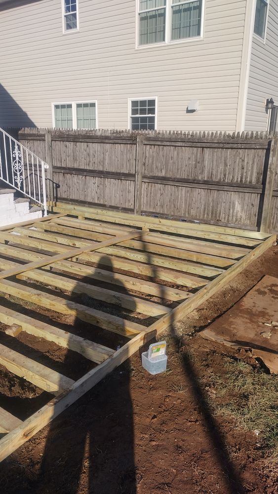 A wooden deck is being built in front of a house