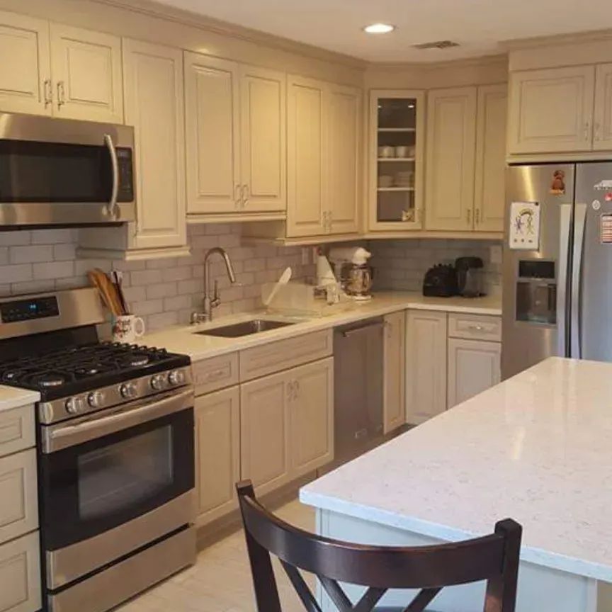 A kitchen with stainless steel appliances and white cabinets