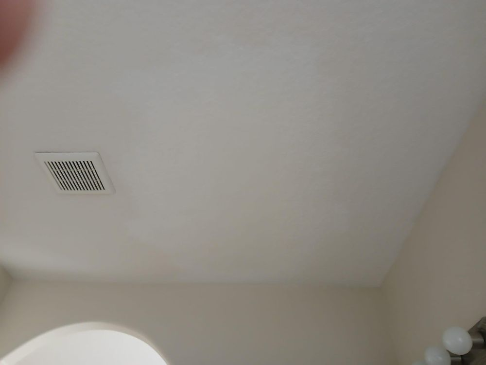 A bathroom with a ceiling fan and a light.