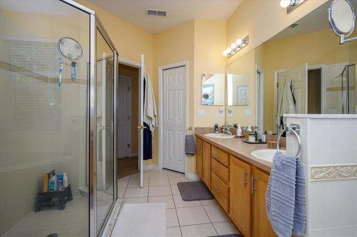 A bathroom with two sinks and a walk in shower