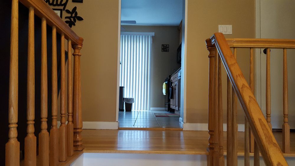A wooden staircase leading up to a living room in a house