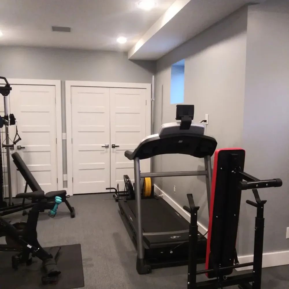 A gym with a treadmill and a bench