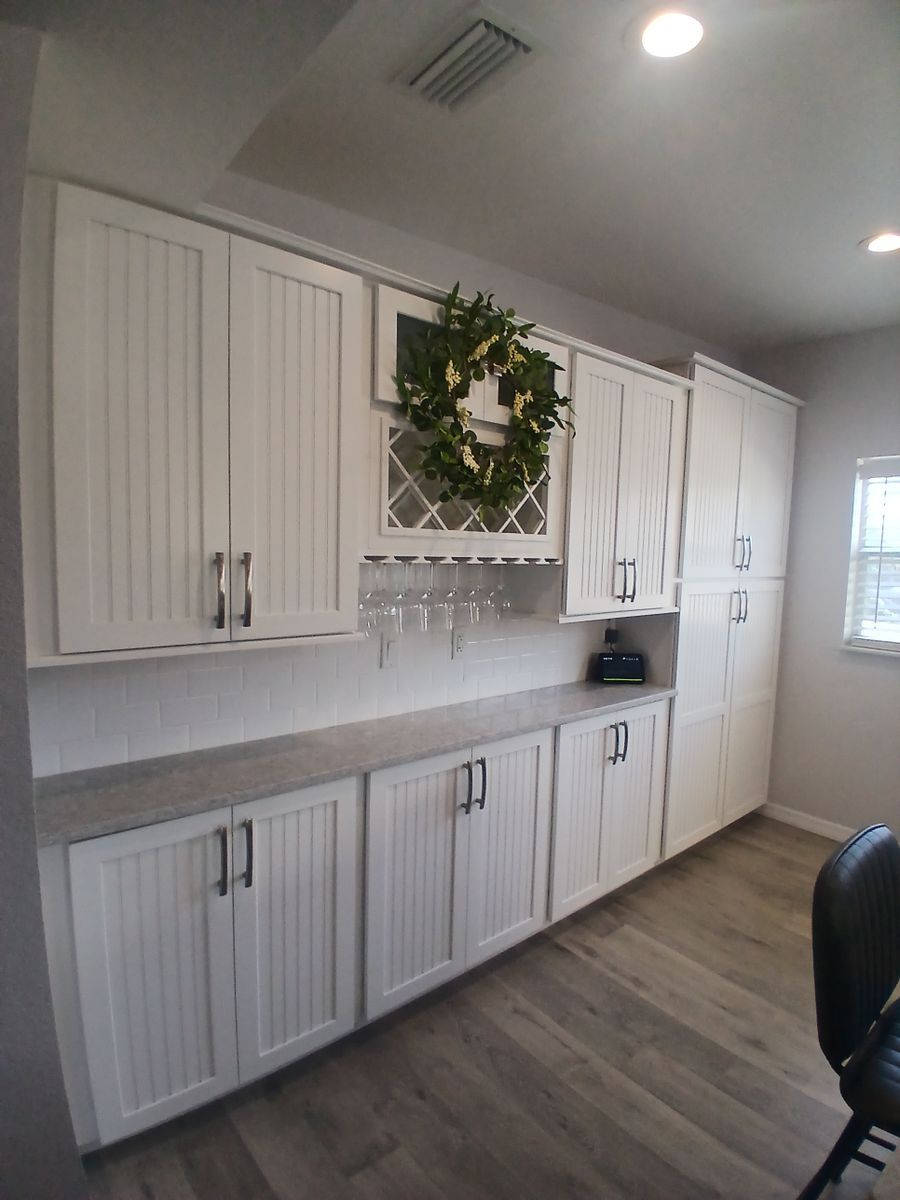 A kitchen with white cabinets and a wreath on top