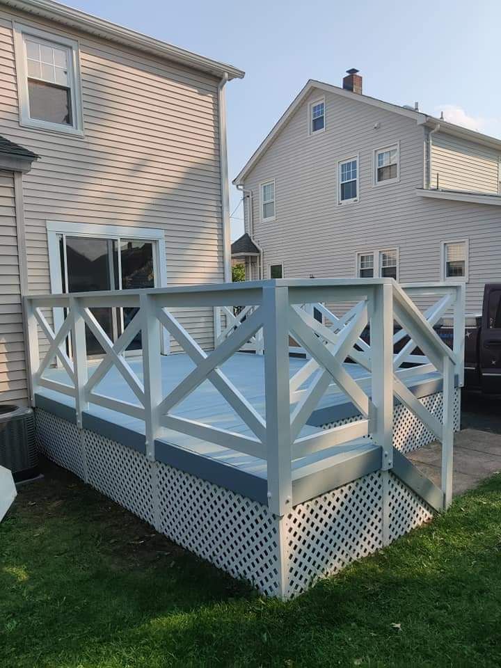 A white deck with a fence in front of a house