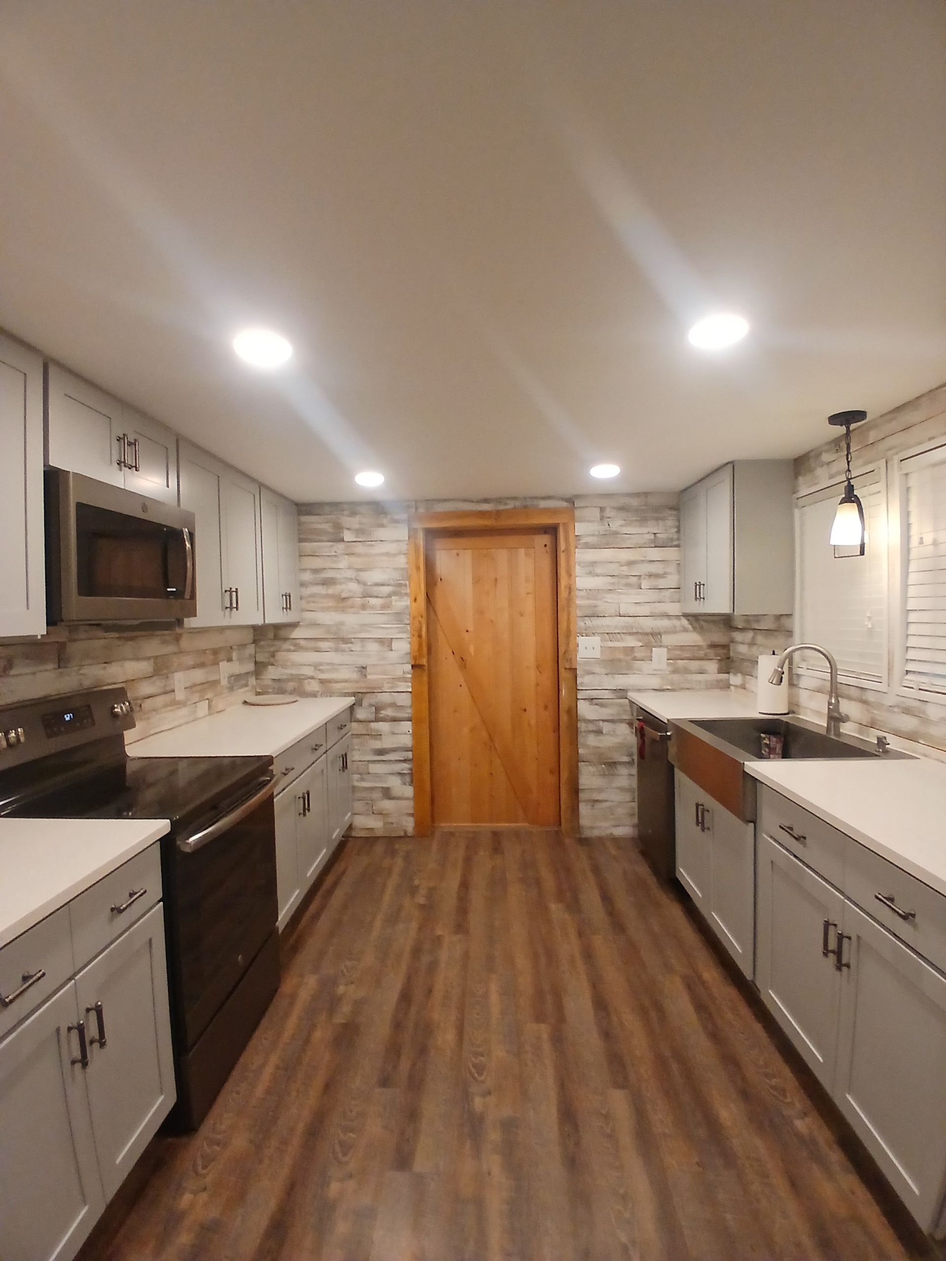 A kitchen with wooden floors and white cabinets