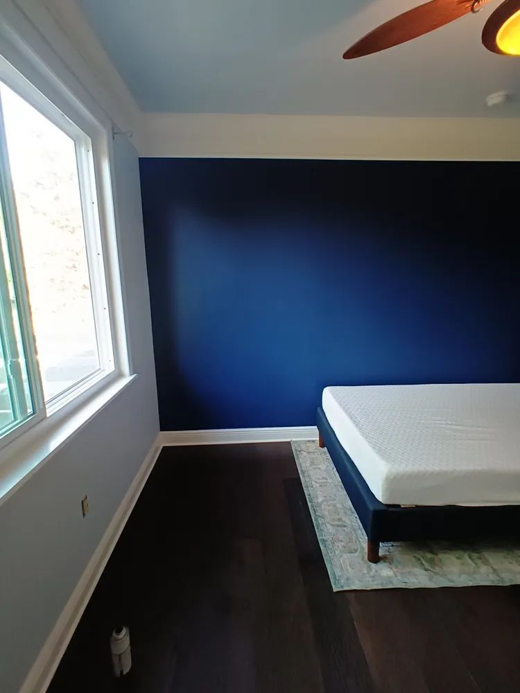 A bedroom with a bed and a ceiling fan