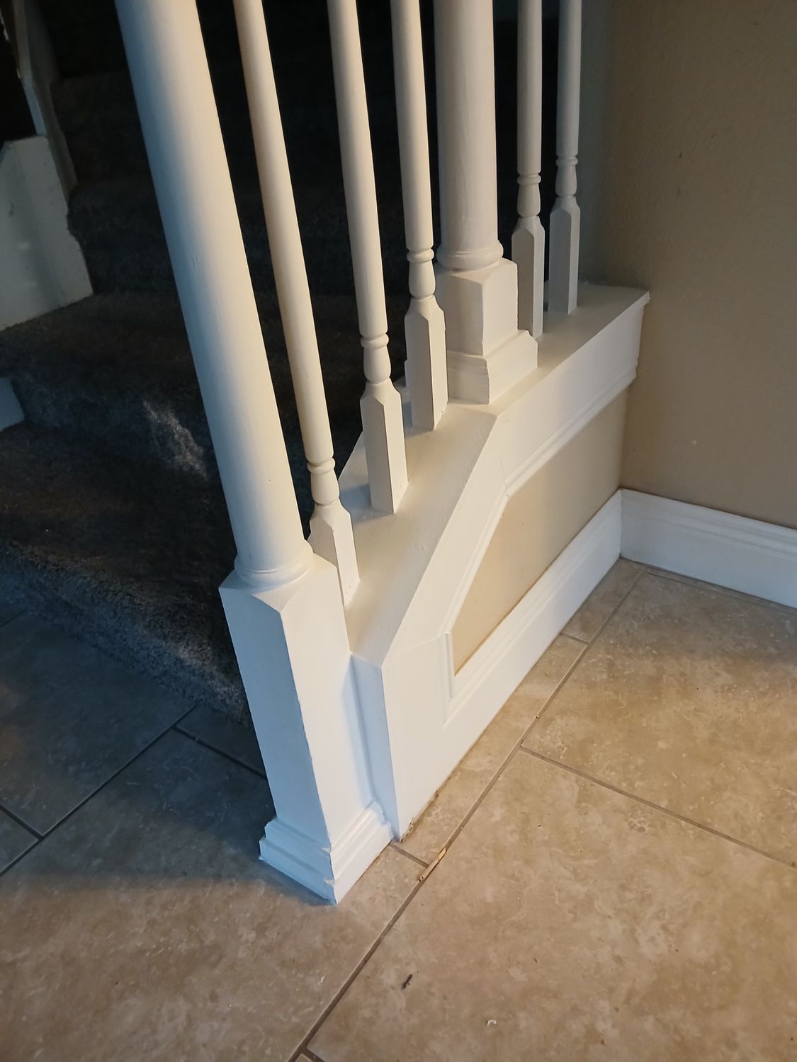 A white railing with a staircase in the background