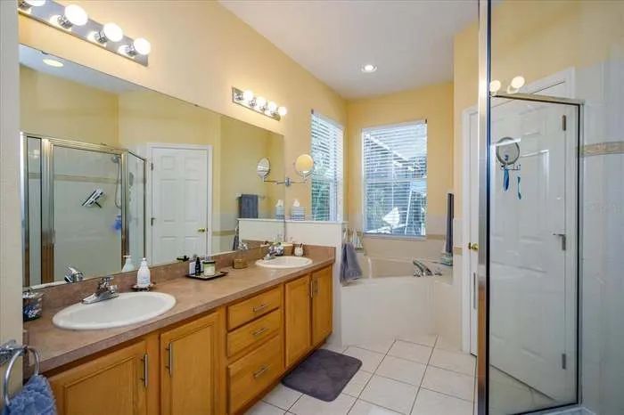 A bathroom with two sinks and a walk in shower