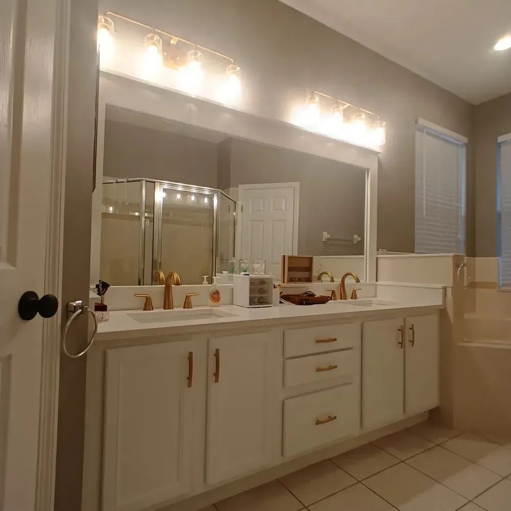 A bathroom with two sinks and a large mirror