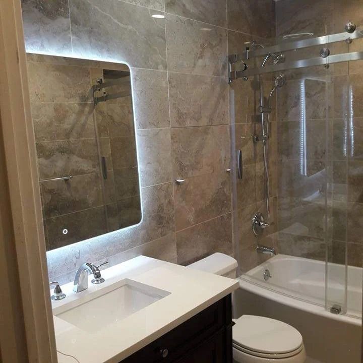 A bathroom with a sink, toilet, tub and mirror
