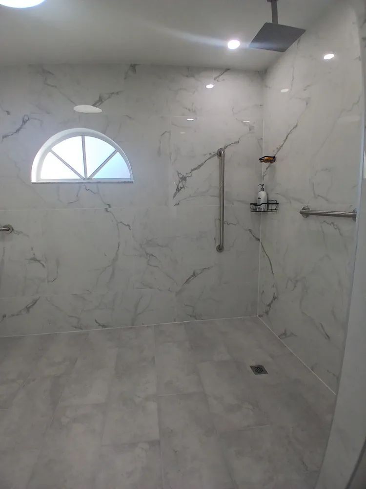 A bathroom with a walk in shower and a window