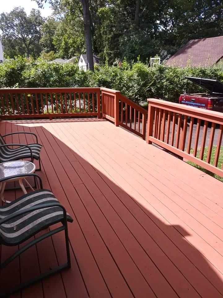A red deck with chairs and a table on it