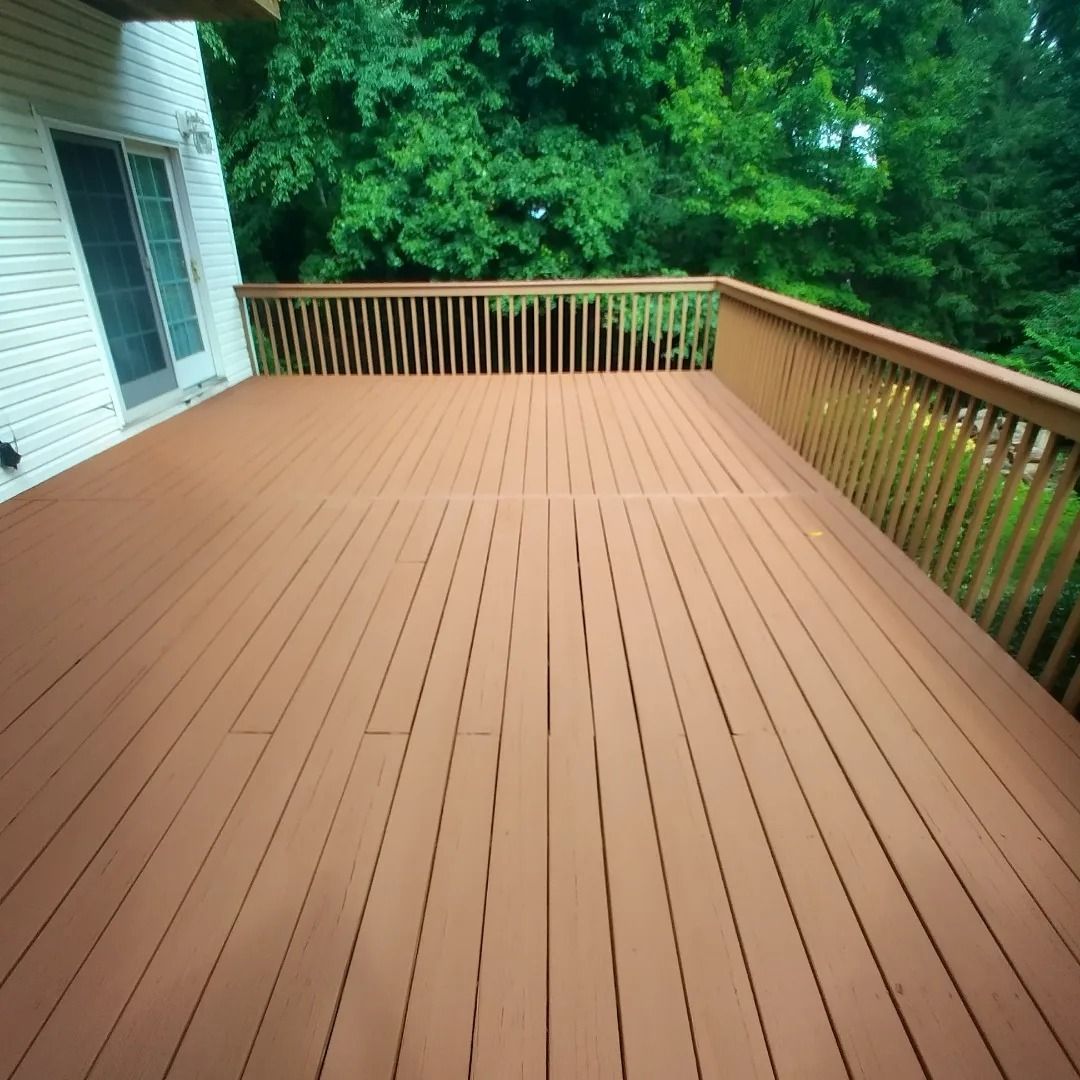 A wooden deck with a railing and trees