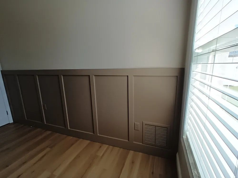 A room with wood paneling and a window with blinds.