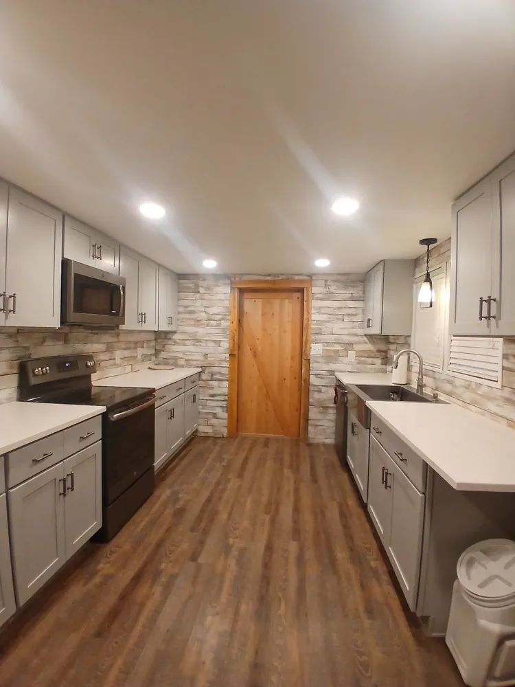 A kitchen with a stove, sink, and microwave