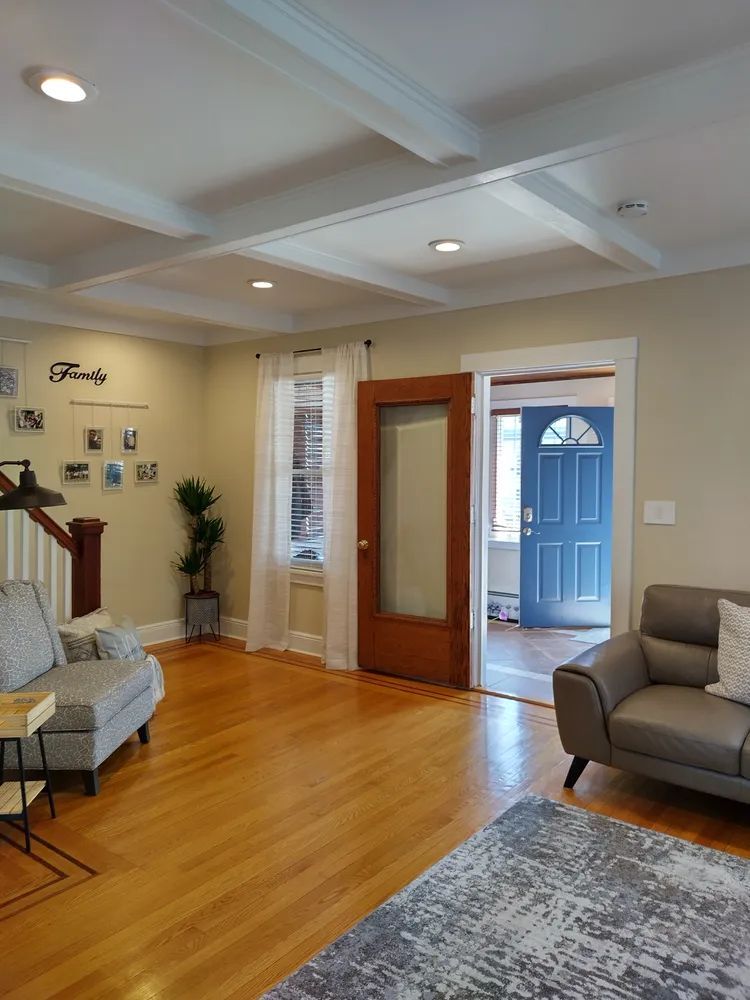 A living room with hardwood floors, a couch, chair and rug
