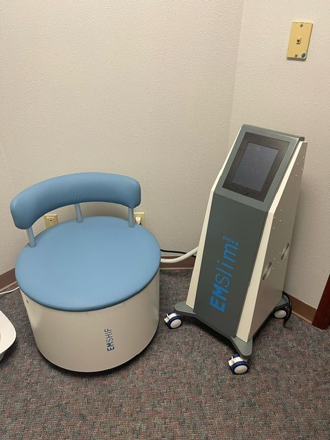 A chair and a machine that says emslim on it