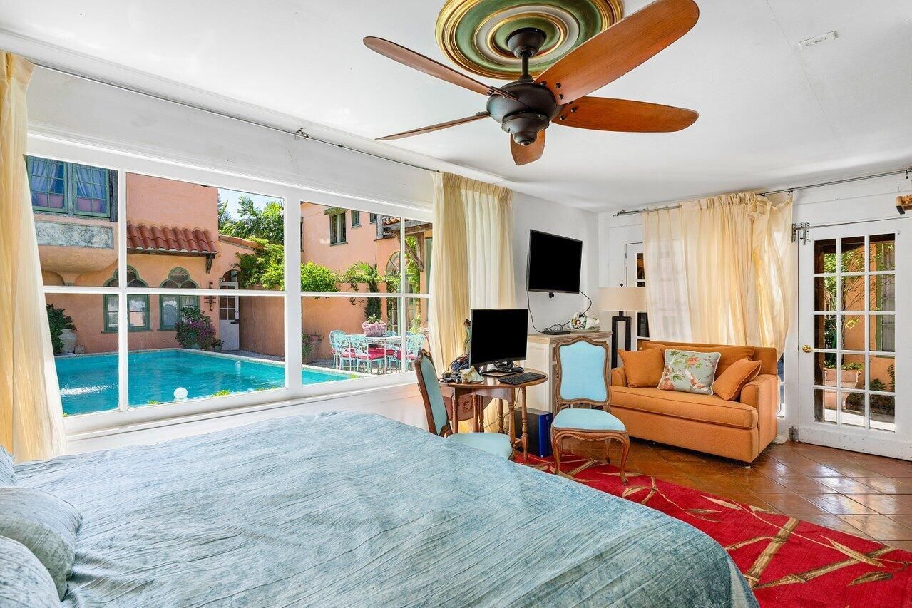 A bedroom with a ceiling fan and a couch