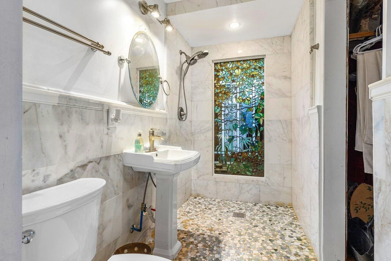 A bathroom with a toilet , sink , and walk in shower.