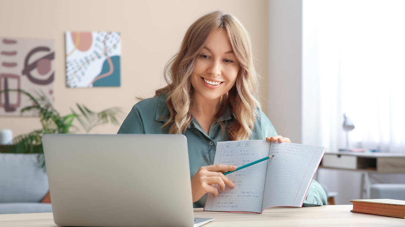 Two people studying documents together at a table. One points with a pencil.
