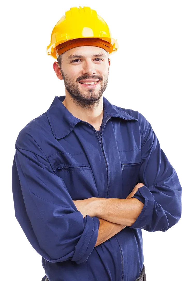 a man wearing a hard hat and blue overalls is standing with his arms crossed .