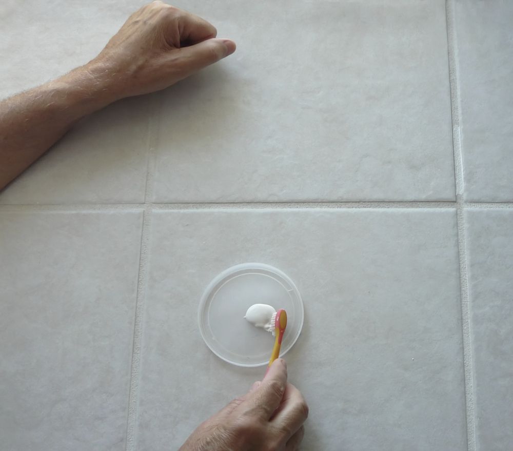 A Person Is Brushing Their Teeth On A Tiled Floor — Tile Power Dubbo In Dubbo, NSW