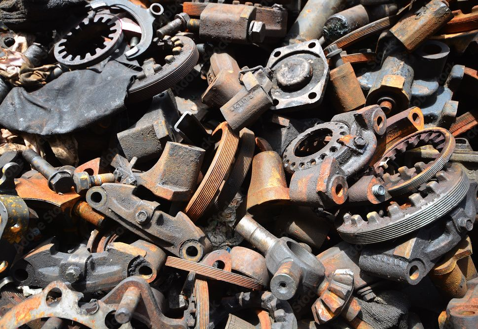 Closeup of a bunch of various rusted scrap metal under sunlight, probably outdoors.][