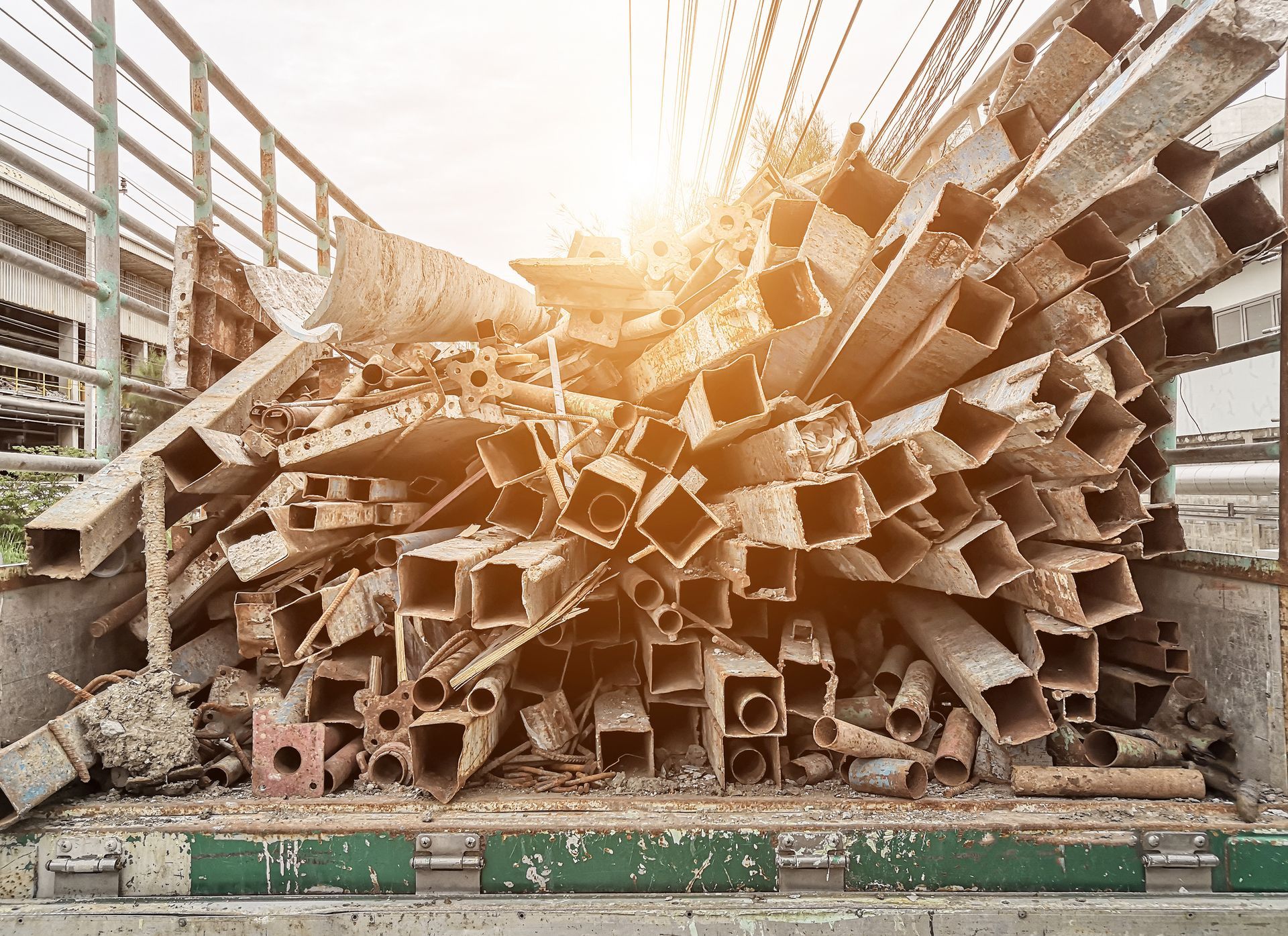 A pile of metal pipes is sitting on the back of a truck.
