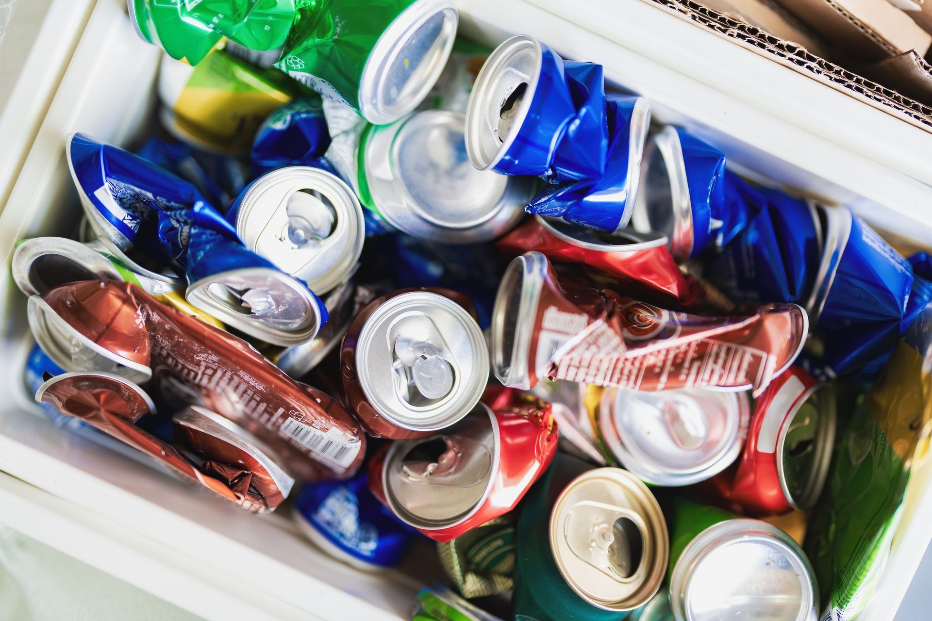 A white box filled with crushed aluminum cans.