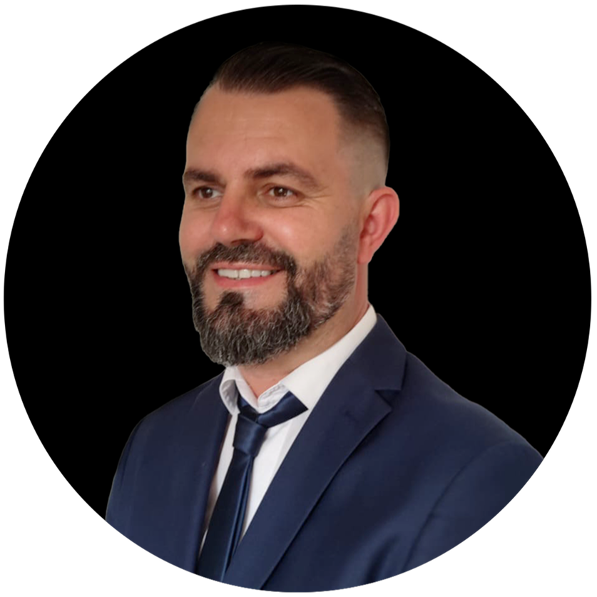 Un uomo con la barba indossa un abito e una cravatta.