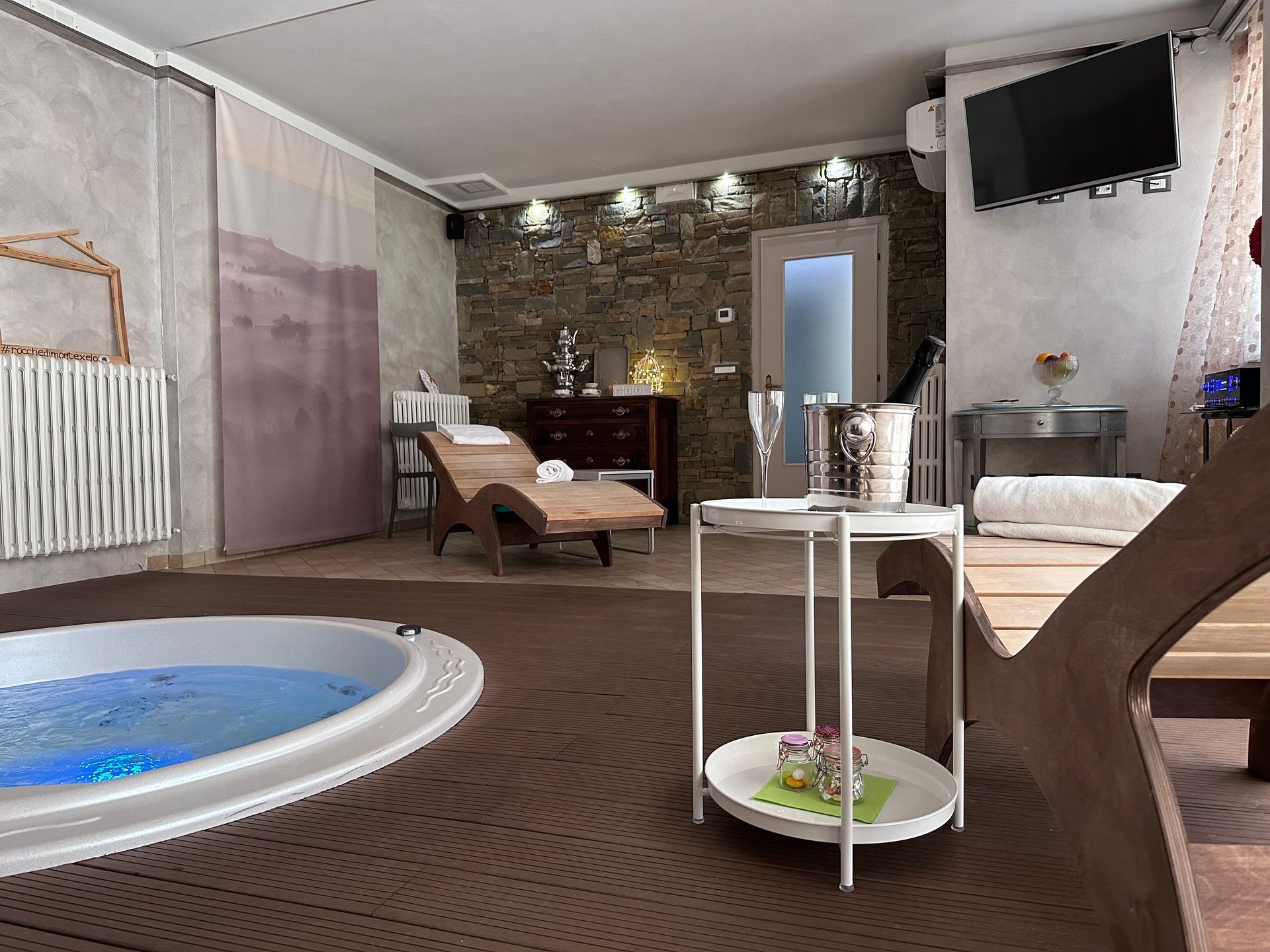 Panoramica della spa privata a Rocche di Montexelo, con idromassaggio, samovar e bottiglia di vino