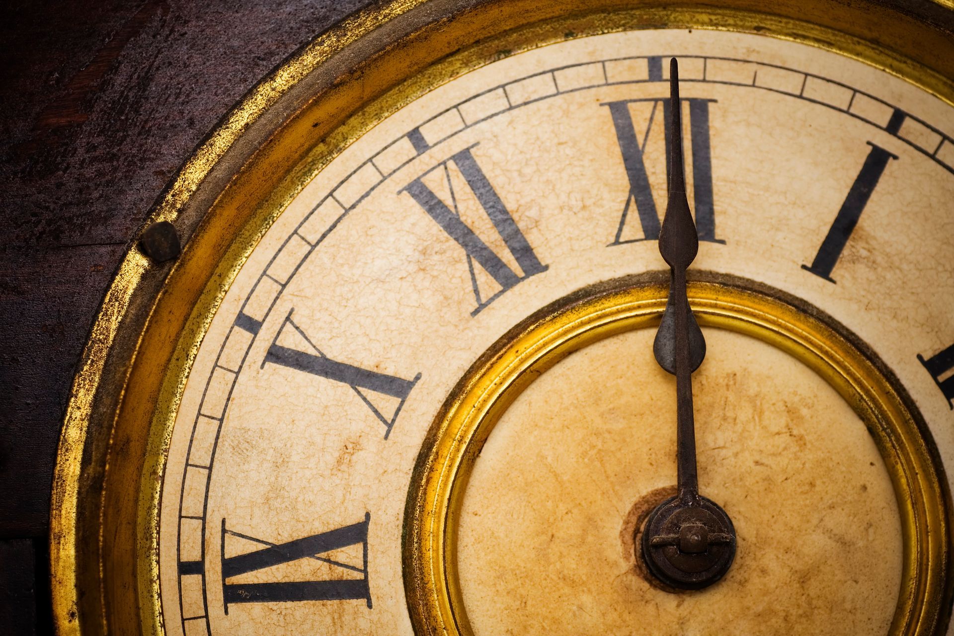 Close-up of antique grandfather clock, showcasing gold gilding and roman numerals face. Close-up of antique grandfather clock, showcasing gold gilding and roman numerals face.