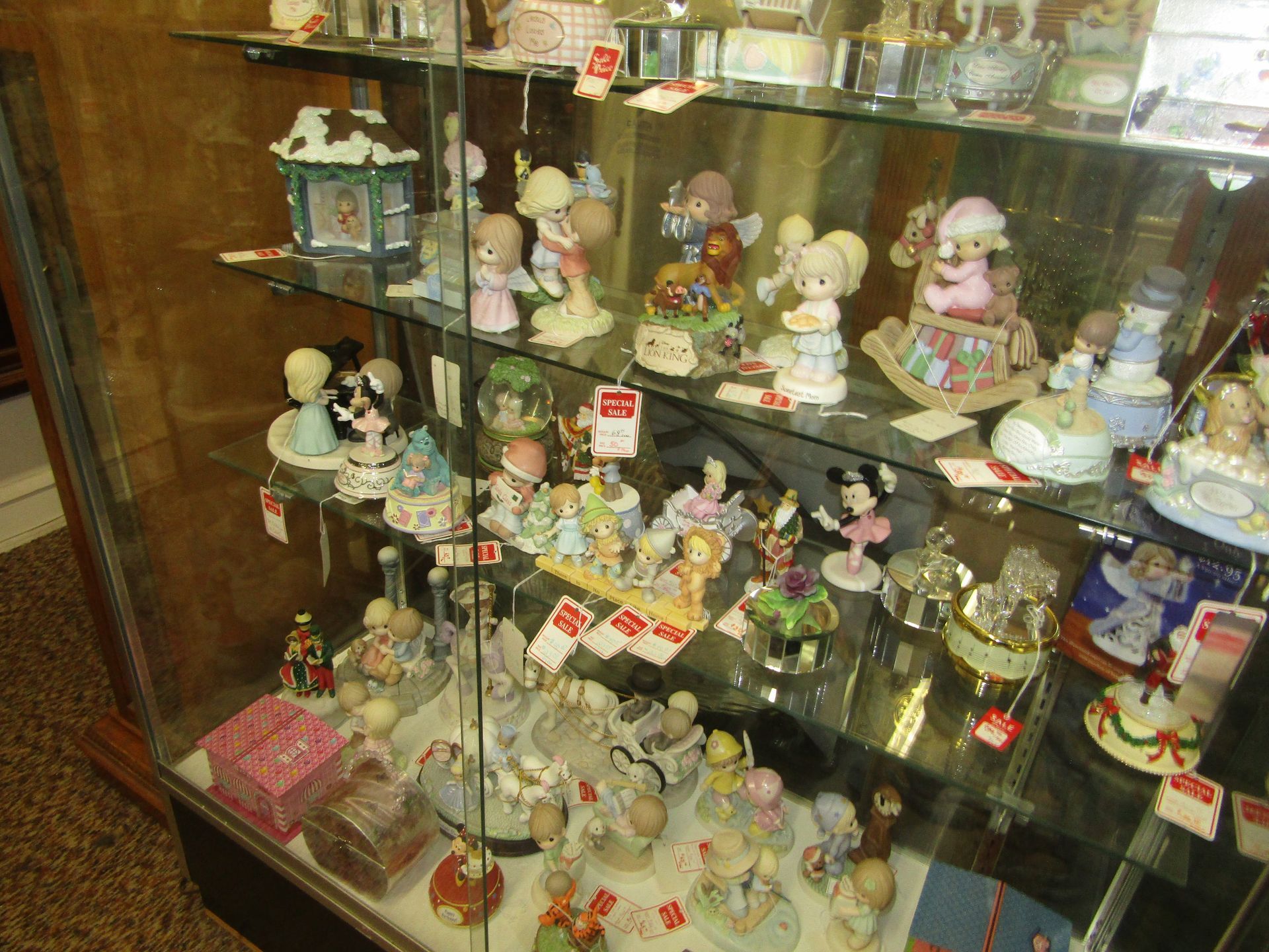 A glass case filled with lots of precious moments figurines