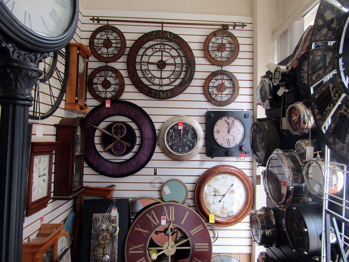 A Display of Clocks on A Wall Including One that Has the Number 12 on It.