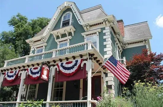 Victorian house with red, white, and blue bunting and an American flag on the porch