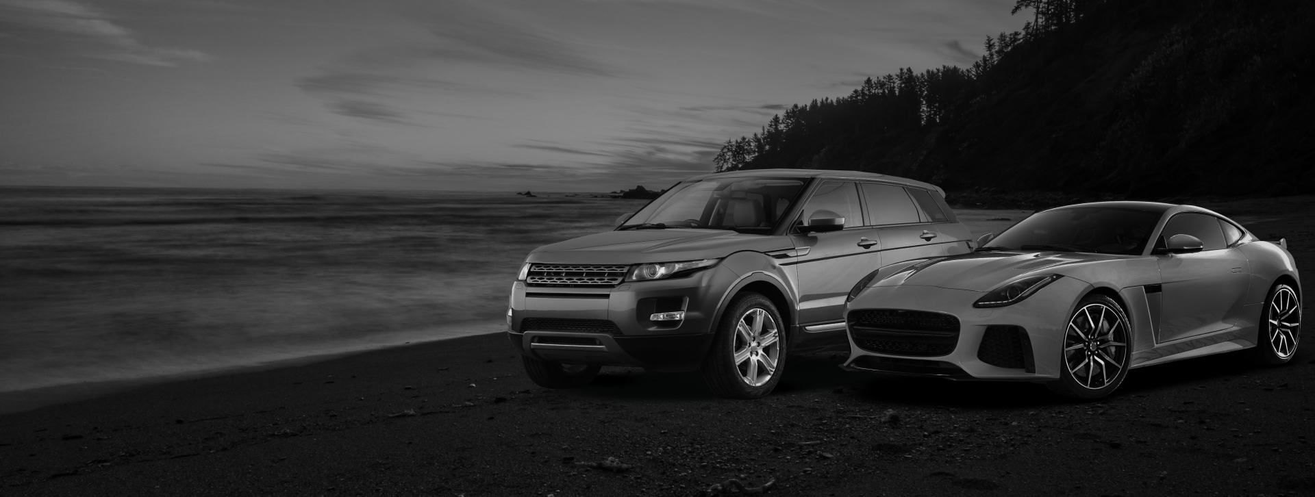 A black and white photo of two cars parked on a beach. | AK Auto Repair