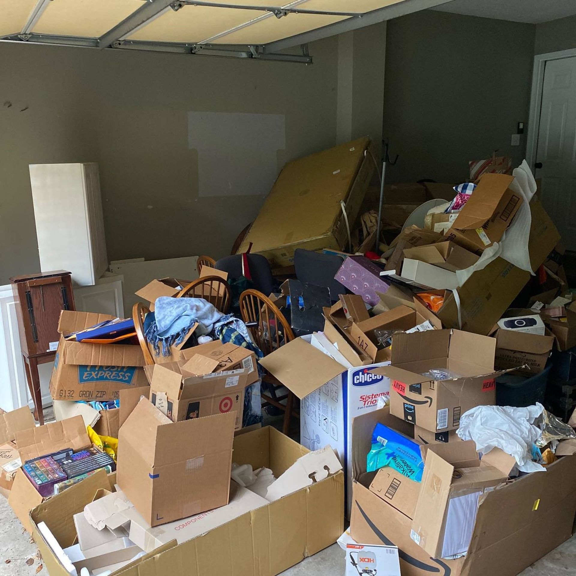 A garage filled with lots of cardboard boxes including one that says amazon on it.