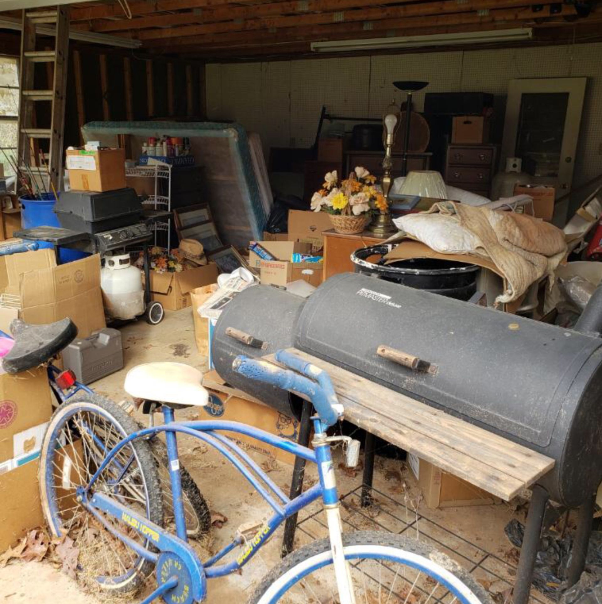 A blue bicycle is parked in a messy garage.