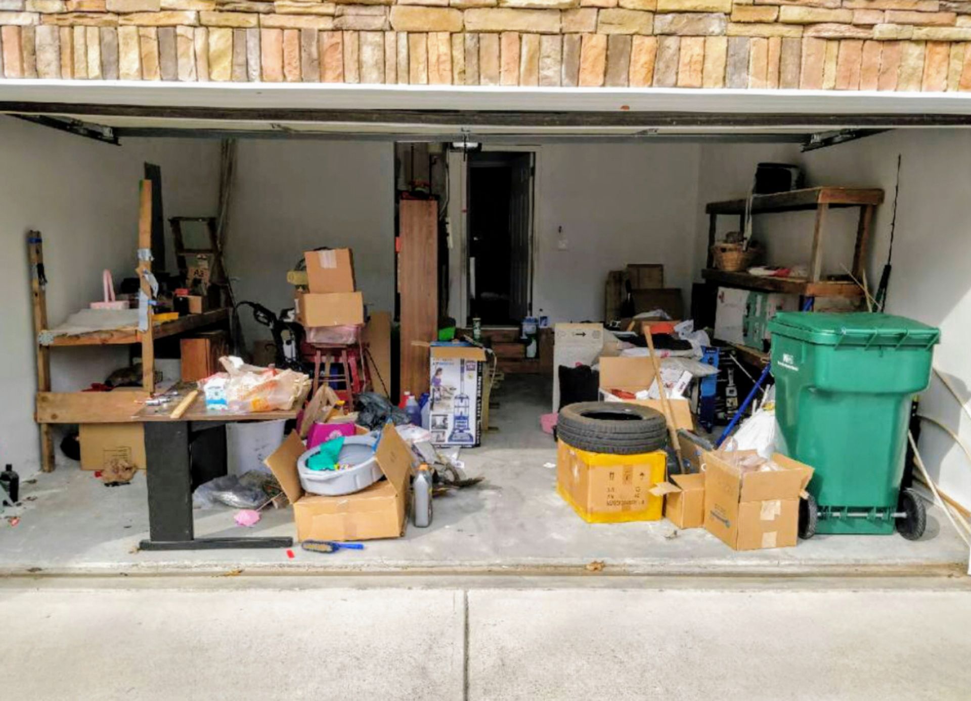 A garage filled with lots of boxes and trash cans.