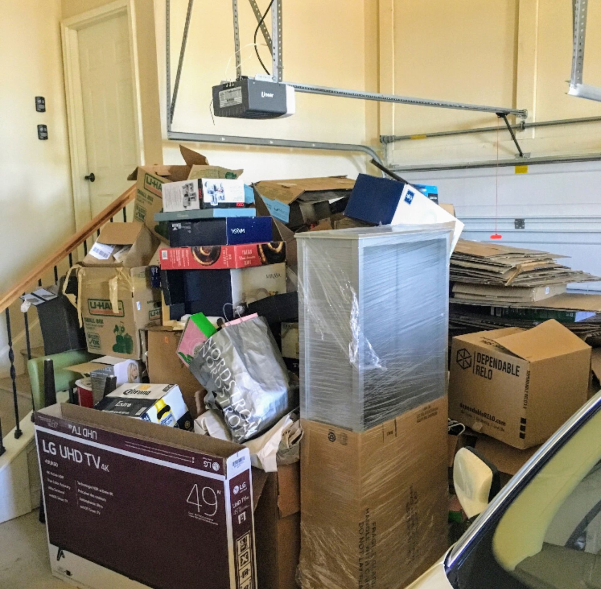 A lg uhd tv is sitting in a garage full of boxes.