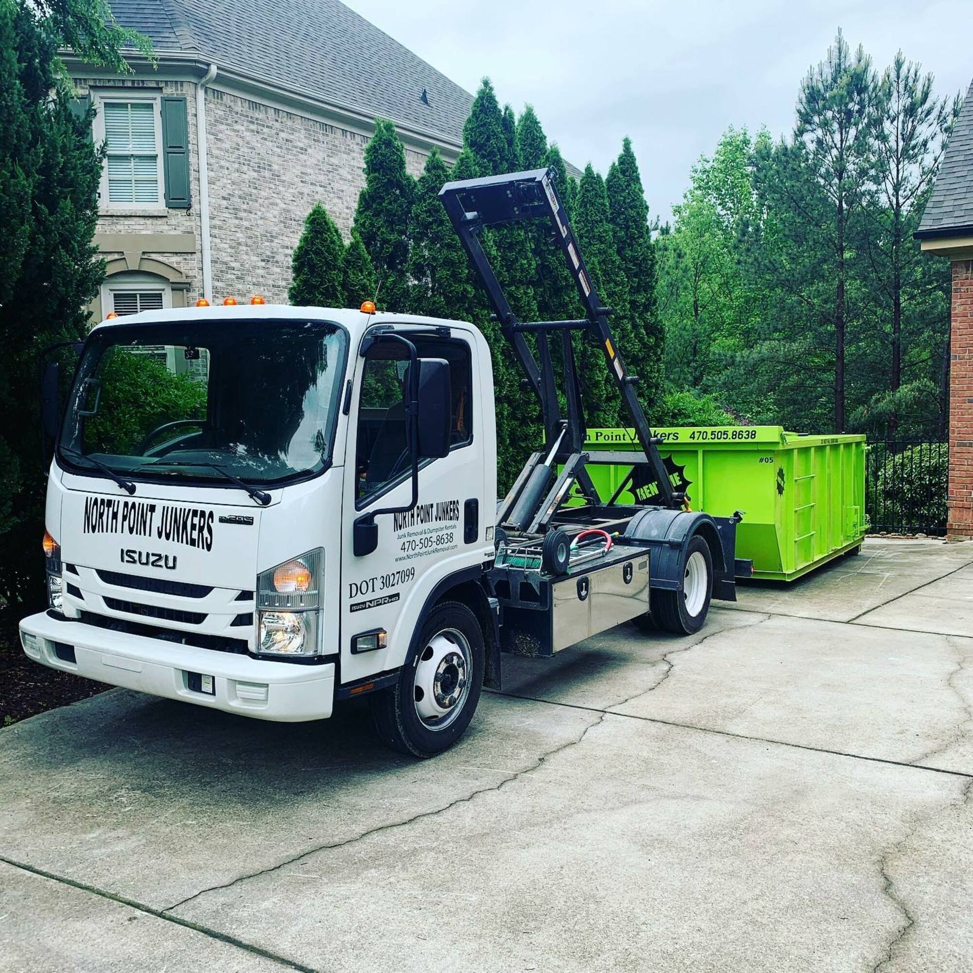 A dump truck is parked in a driveway next to a house.