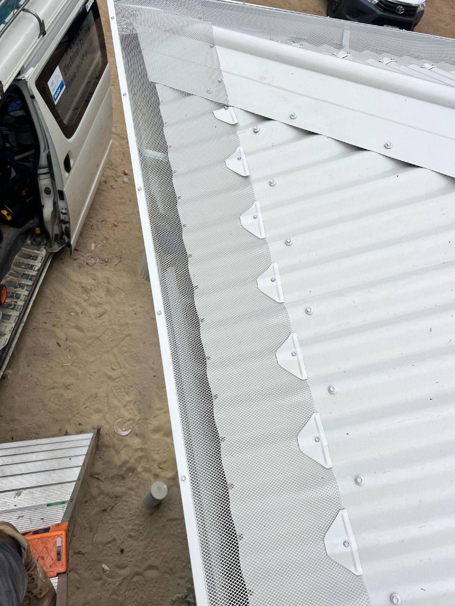 A close up of a gutter on a perforated wall.